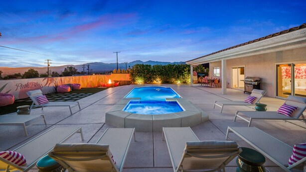 An outdoor swimming pool area with lounge chairs and a patio. - PinkBlissHouz: Pool, Spa, Firepit, Themed Rooms (Desert Hot Springs)