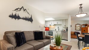 Ein modernes Wohnzimmer mit einer Couch, einem Couchtisch und einem Essbereich mit Stühlen und einem Tisch.
