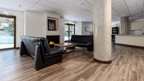 Eine geräumige Lobby mit Kamin, Ledersofas und einer großen Säule.