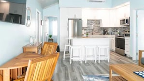 Una cocina moderna con armarios blancos, una isla central y electrodomésticos de acero inoxidable.