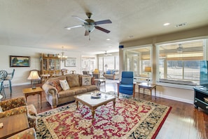A spacious living room with a large coffee table, comfortable seating, and a ceiling fan.