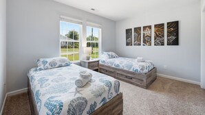 A bedroom with two beds, a window with a view, and four wall-mounted artworks. - Private home along New River NC (Sneads Ferry)