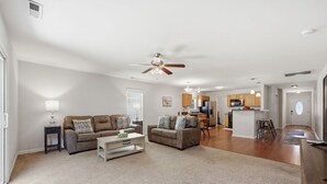 A spacious living room with two sofas, a coffee table, and a ceiling fan. - Private home along New River NC (Sneads Ferry)