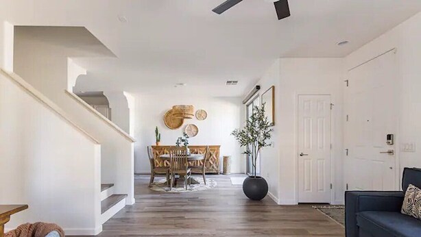 A spacious living room with a dark-colored sofa, a coffee table, and a staircase leading to another level.