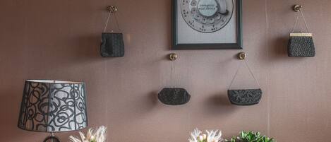 A vintage telephone, a lamp, and several handbags on a wall.