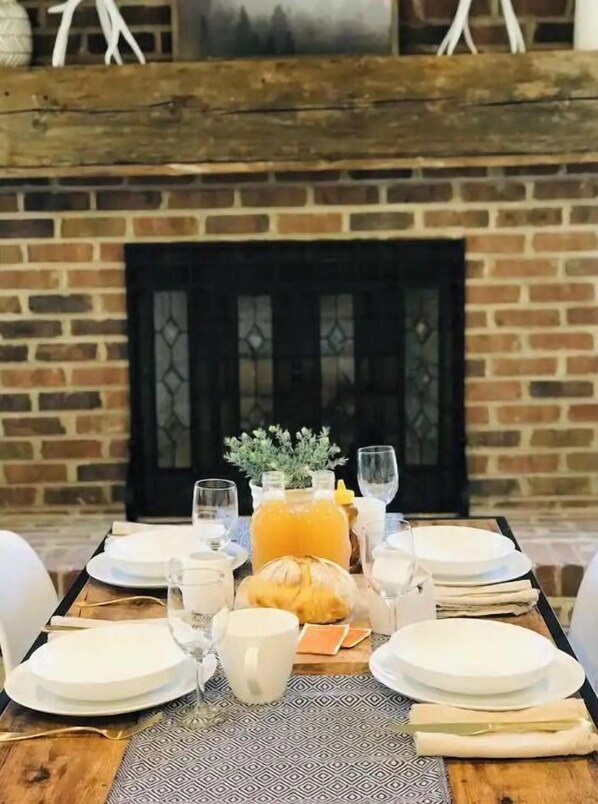 Enjoy a warm meal at this inviting dining table, set in front of a crackling fireplace.
