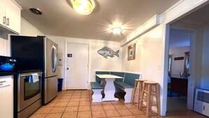 Una cocina con comedor, que incluye una mesa y sillas, un refrigerador y una estufa.