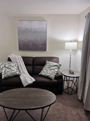 Relax in this stylish living room with a sofa, coffee table, and abstract art.