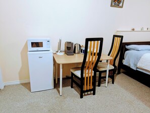 A compact room with a kitchenette, a wooden dining table, two chairs, and a bed with a blue blanket. - Quiet and big room in Coquitlam (Coquitlam)
