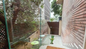 A glass-walled balcony with a doormat, a small table with chairs, and a potted plant. - Three flats close to Vatican - Prati (roma)