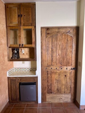 Una cucina con mobili in legno, una macchina per il caffè e un frigorifero.