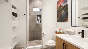 Un baño moderno con ducha, inodoro y tocador.