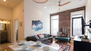 A modern living room with a dining area, a fireplace, and a large window with a view. - ✪ Best Apartment in Westport Kansas City ✪ (Kansas City)