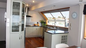 Una cocina moderna con comedor, que cuenta con un amplio ventanal, un reloj y un armario empotrado.