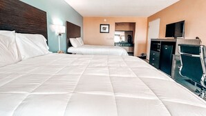 Habitación de hotel con dos camas, televisión, escritorio y silla.