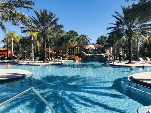 Relax by the serene pools surrounded by palm trees and a soothing waterfall.