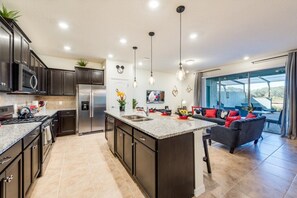 Enjoy cooking in this well-lit kitchen with a central island, oven, and large window offering a view of the outdoors.