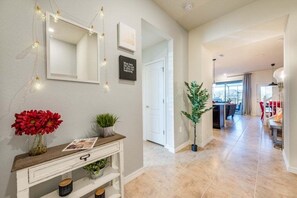 Stunning hallway leads to a spacious dining area with a modern kitchen and large window.