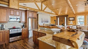 Cucina spaziosa con mobili in legno, un piano di lavoro in granito e una grande isola.