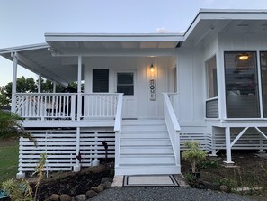 Welcome to a charming home with a covered porch and lush garden.