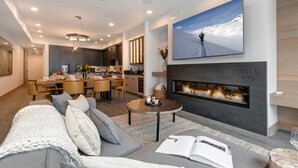 Ein modernes Wohnzimmer mit Kamin, Essbereich und Küche.