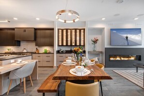 Une cuisine moderne avec une table à manger en bois, des placards intégrés et une cheminée.