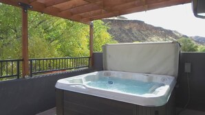 A hot tub on an outdoor balcony with a view of a mountainous landscape. - Silver Reef Mine | Ball Pit & Hot Tub (Hurricane)