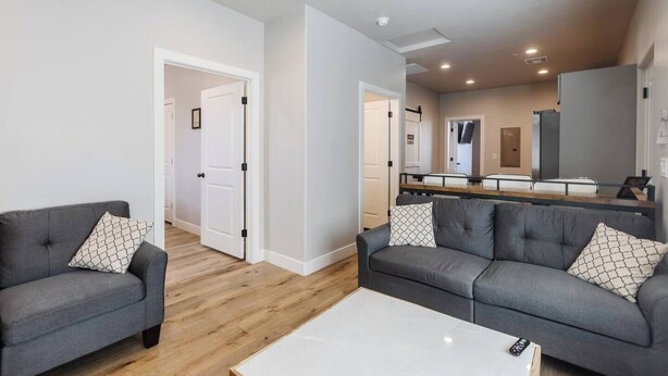 A modern living room with two grey sofas, a white coffee table, and a wooden floor. - Silver Reef Mine | Ball Pit & Hot Tub (Hurricane)