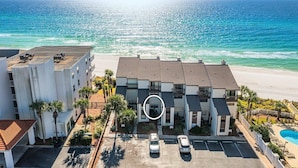 Un hôtel situé en bord de mer, avec plusieurs étages, un parking et un espace piscine.