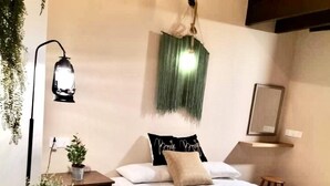 A neatly arranged bedroom with a bed, bedside tables, a hanging light fixture, and a wall-mounted mirror. - Le meilleur (George Town)
