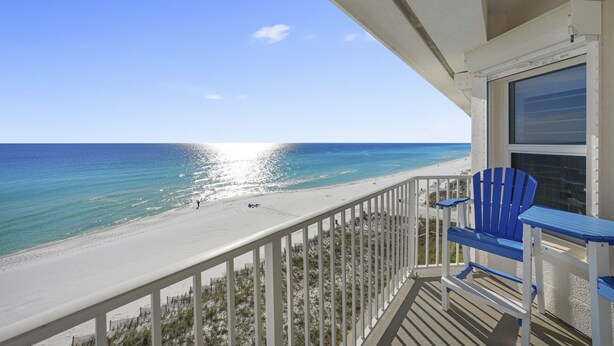 A balcony with a view of a beach and ocean.