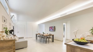 A modern living room with a dining area, a kitchen counter with fruits, and a TV on the wall. - 2503 B&B Villa Eragea - Camere Superior by Barbarhouse (Matino)