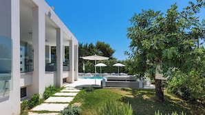 A modern outdoor pool area with a clear blue sky, a well-maintained lawn, and a seating area with umbrellas. - 2503 B&B Villa Eragea - Camere Superior by Barbarhouse (Matino)