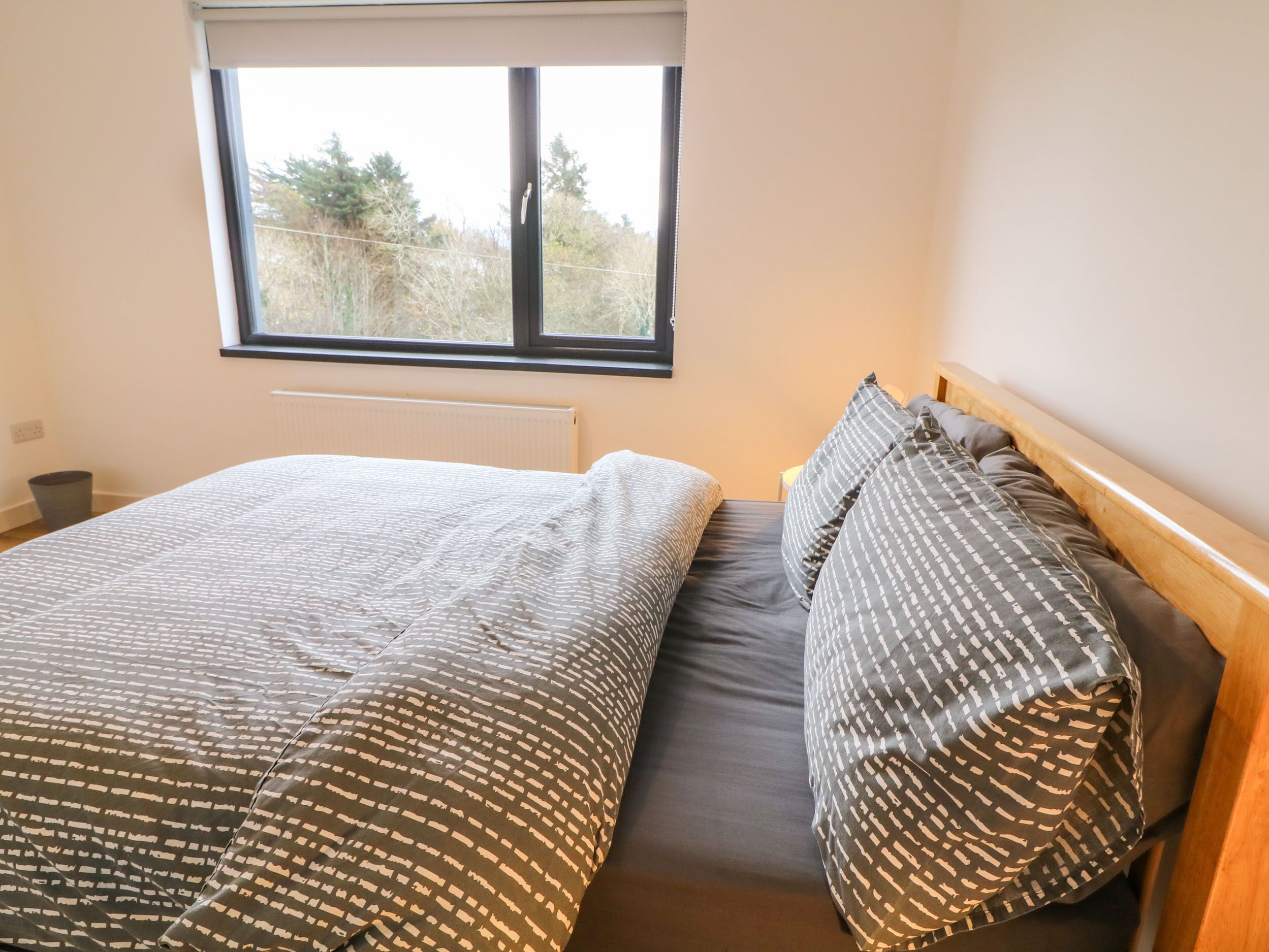 A bedroom with a bed, a window, and a radiator.