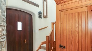 A wooden door with a small window, a stone wall, and a wooden staircase with a handrail. - 2 Yr Hen Felin (Haverfordwest)