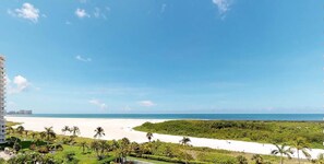 Na praia, espreguiçadeiras, toalhas de praia 