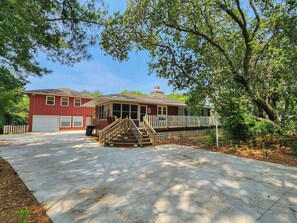 A two-story house with a front porch and a staircase leading to the entrance. - The Circle R - Cozy 3 bedroom oceanside beach cottage w/Private Pool & Dogs Allowed (Southern Shores)