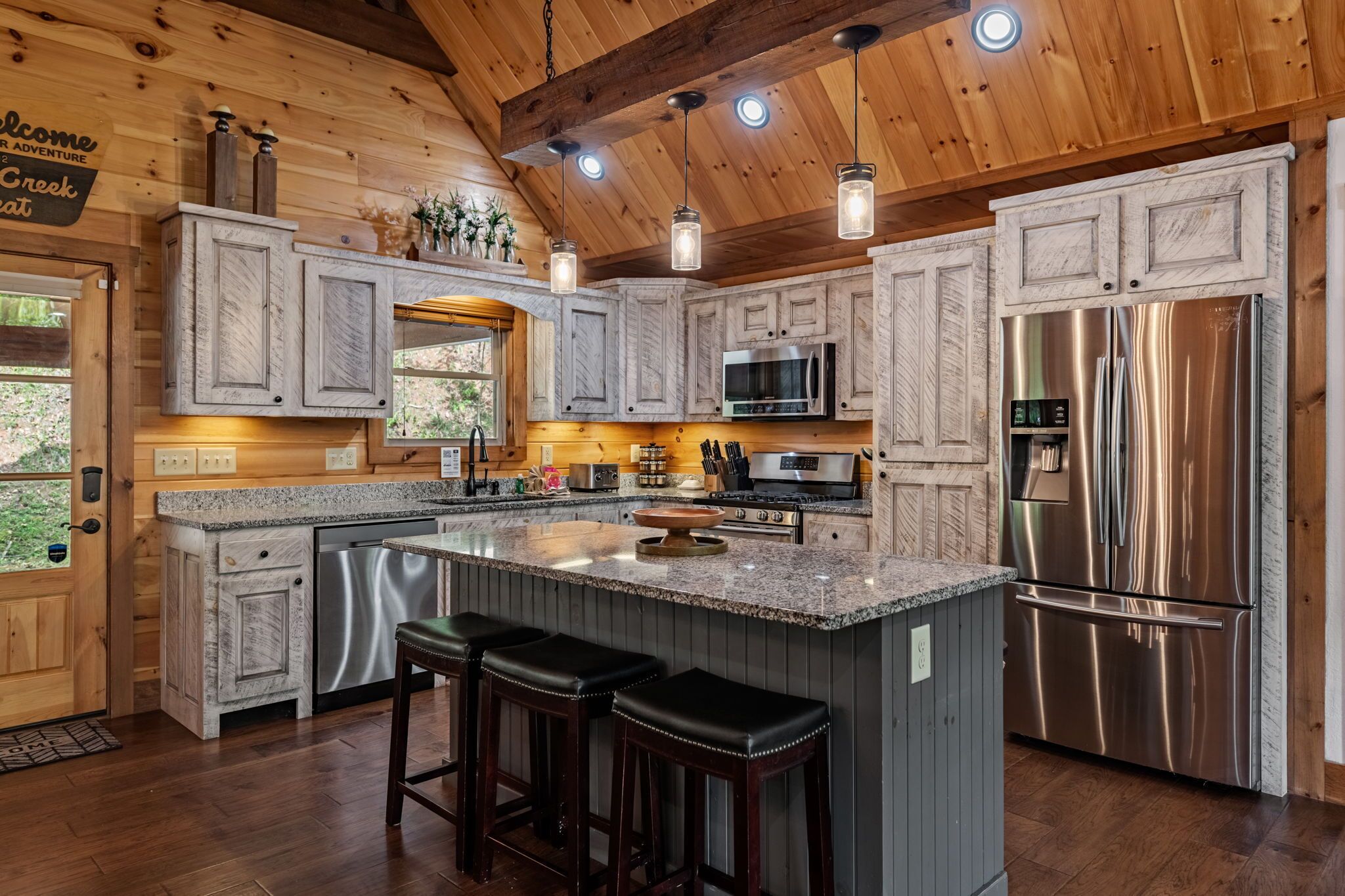 A modern kitchen with granite countertops, stainless steel appliances, and wooden cabinetry.