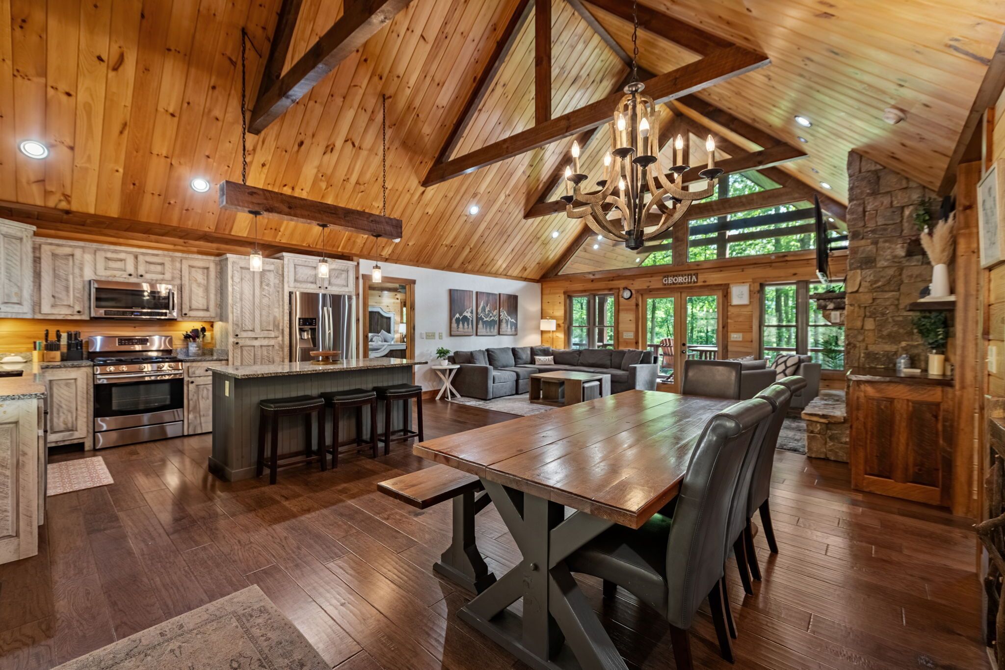 A spacious kitchen with wooden cabinets, a large island, and a dining area with a wooden table and chairs.