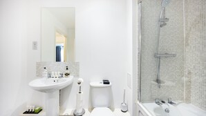 Une salle de bain moderne équipée d’un lavabo, de toilettes et d’une douche.