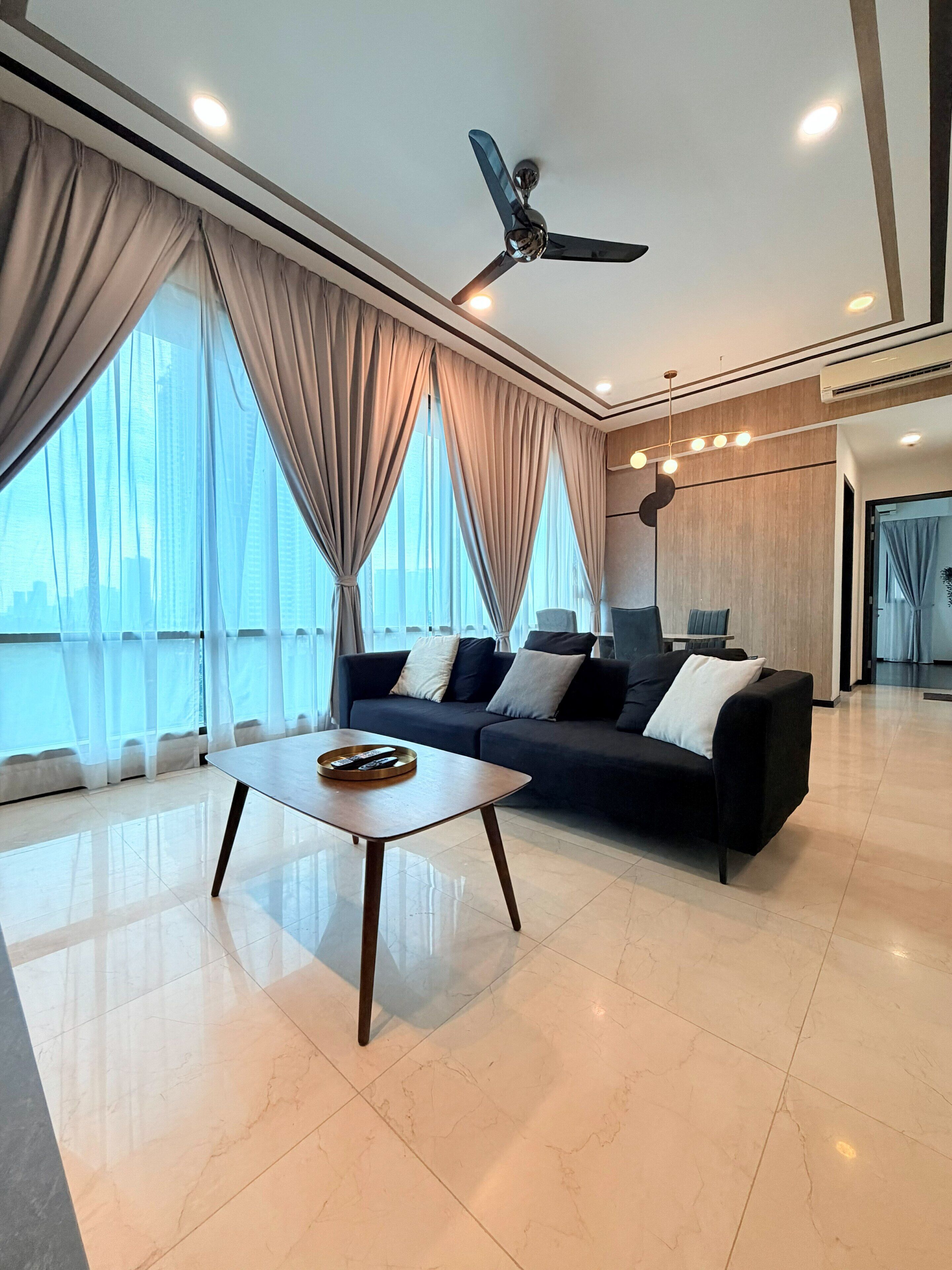 A modern living room with a sofa, coffee table, and a ceiling fan.