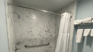 A bathroom with a shower, toilet, and towel rack. - Star Inn Motel (Costa Mesa)