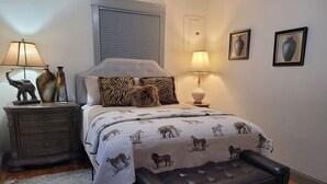 A bedroom with a bed, two nightstands, a lamp, a rug, and a bench. - Downtown Cozy Getaway (Fort Smith)