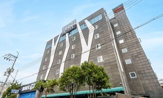 Un edificio de hotel de diseño moderno, con un letrero destacado que dice 'HOTEL' en la parte superior.