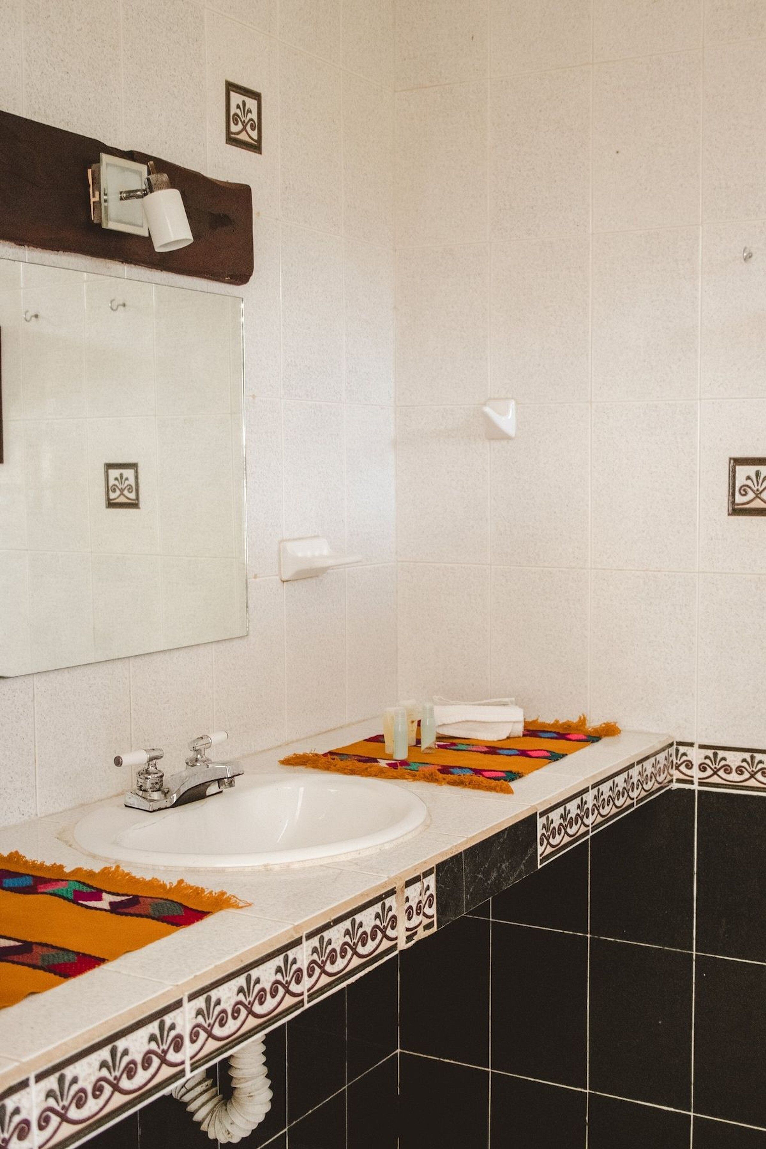 A bathroom with a white sink, a mirror, and a towel rack.