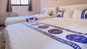 Habitación de hotel con dos camas, una ventana con cortinas, un equipo de aire acondicionado, una mesita de noche y un cuadro colgado en la pared.