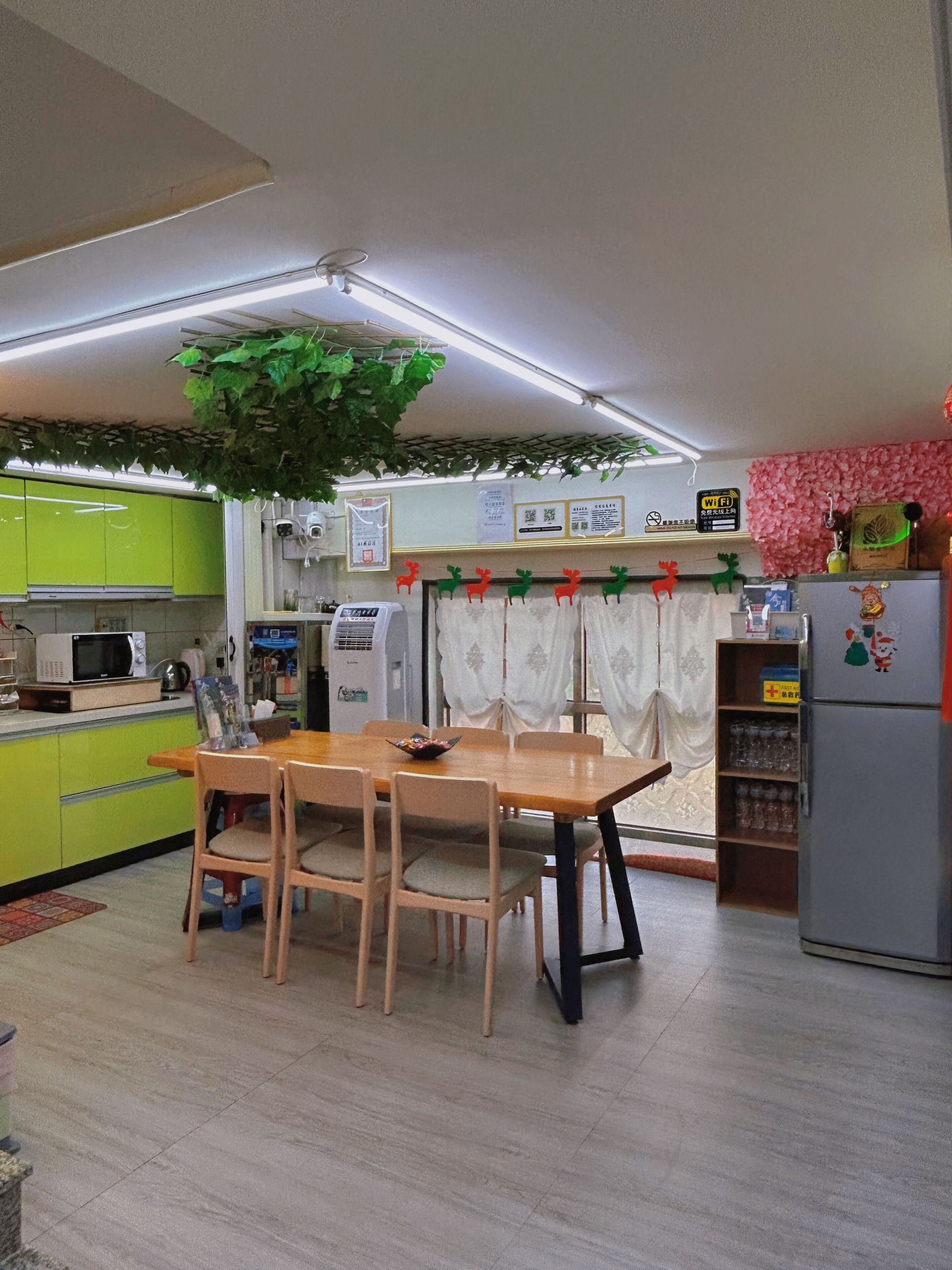 Une cuisine compacte comprenant une table à manger, des chaises, un réfrigérateur et un four à micro-ondes.