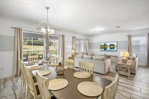 Cozy living area with a dining table for four, comfortable seating, and a large window overlooking a lush garden.