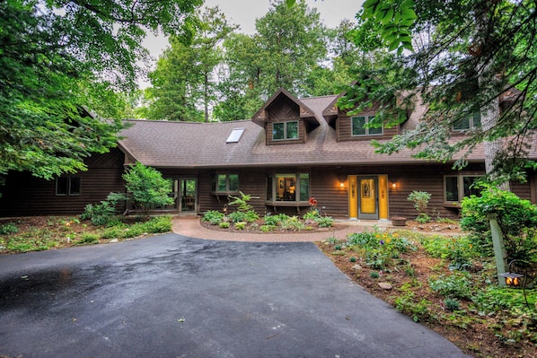 A wooden house with a sloped roof, a front porch, and a well-maintained garden.