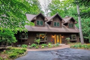 A wooden cabin with a sloped roof, multiple windows, and a front entrance.